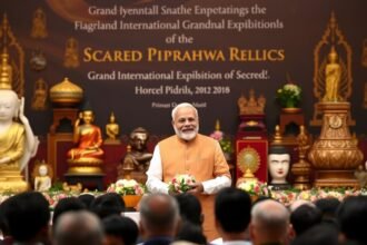 A photo of Prime Minister Narendra Modi inaugurating the Grand International Exposition of Sacred Piprahwa Relics, with a backdrop of Buddhist artifacts and a crowd of people in the foreground.