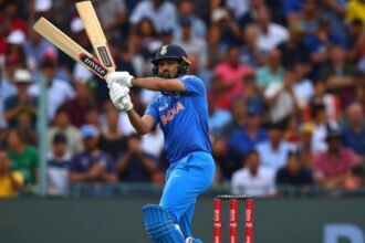 An image of Hardik Pandya hitting a six in a cricket match, with a thrilled crowd in the background and the scoreboard showing his impressive score.