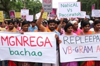 A photo of a protest in Karnataka with people holding signs that read "MGNREGA bachao" and "Repeal VB-G RAM G Act"