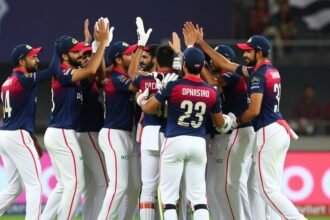 A photo of the Delhi Capitals team celebrating a win, with the top order batsmen in focus, highlighting their key role in the team's success.