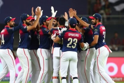 A photo of the Delhi Capitals team celebrating a win, with the top order batsmen in focus, highlighting their key role in the team's success.