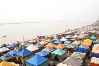 A photograph of the Varanasi Tent City with the Ganga River in the background, highlighting the environmental concerns.