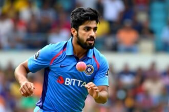 A photo of Vaibhav Suryavanshi in action on a cricket field, with a ball in hand and a determined look on his face, with a blurred background of a stadium crowd.